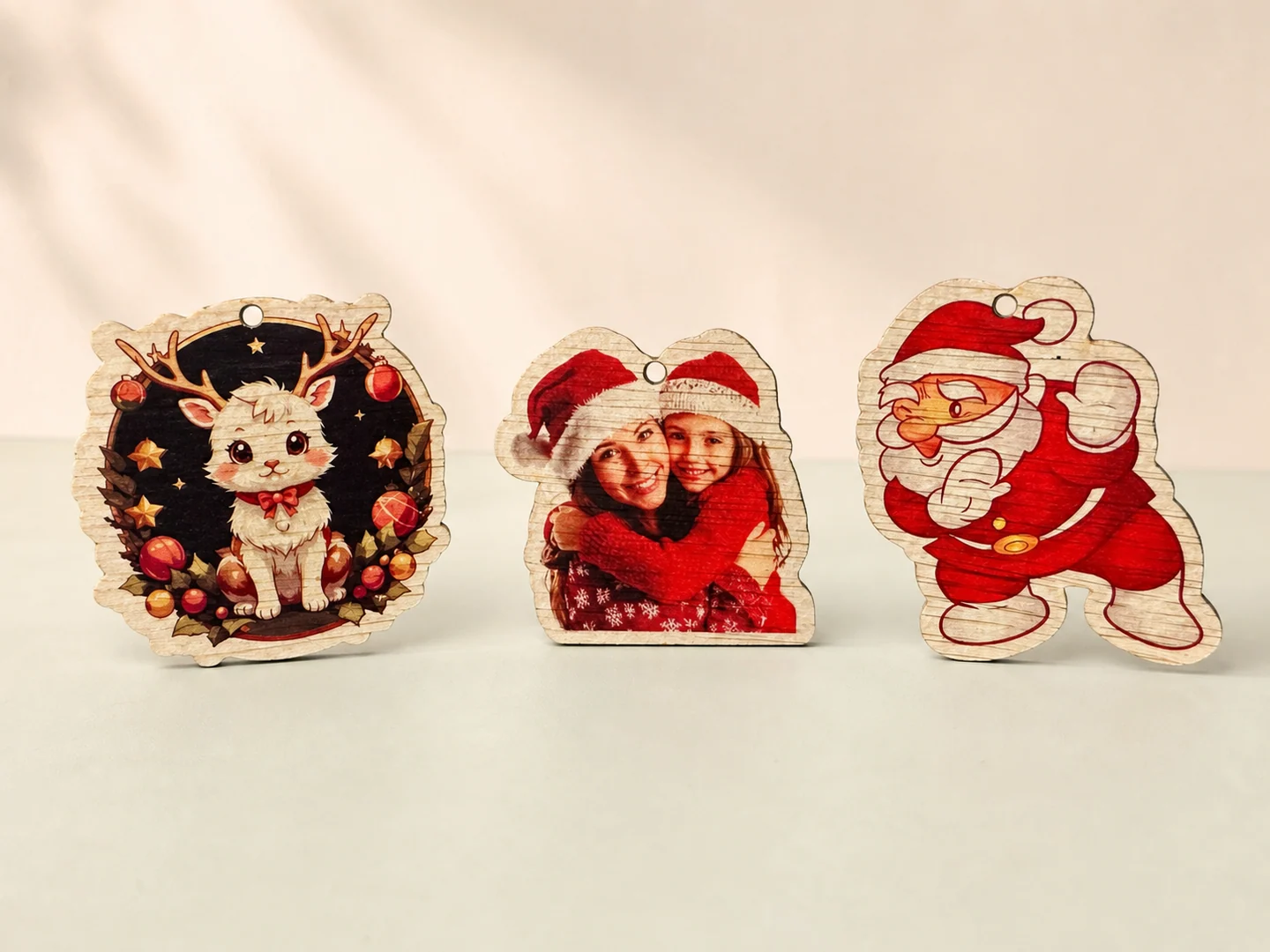 Trei ornamente din lemn cu o pisică festivă, o fotografie de familie și Moș Crăciun