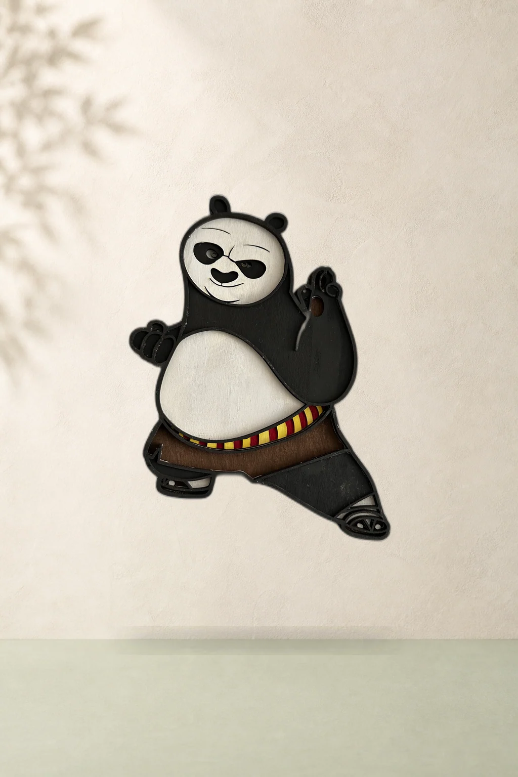 Panda din lemn stratificat, alb-negru, cu detalii colorate, așezat pe o hartă